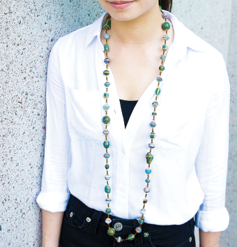A woman wearing a long-beaded necklace.