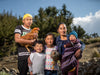 A family of five smile for the camera while holding two chickens in their arms.
